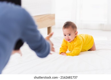 Asian Happy Young Mother Have Fun Learn Walking Crawling His Daughter Baby Indoors Bedroom At Home. The Mom Playing With Her Little Baby To Crawl, Two Family