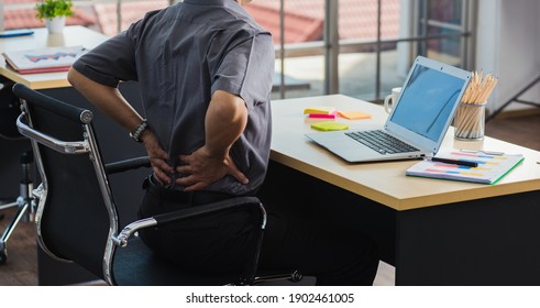 Asian Hard Senior Businessman Working With Laptop Computer Has A Problem With Back Pain. Old Man Feeling Pain After Sitting At Desk Long Time, Healthcare And Medicine Office Syndrome Concept