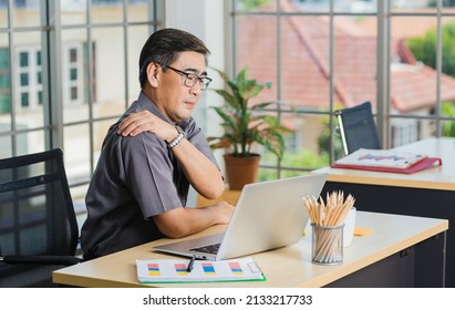 Asian hard senior businessman working with laptop computer has a problem with shoulder pain. Old man feeling pain after sitting at desk long time, Healthcare and medicine office syndrome concept - Powered by Shutterstock