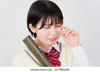 Asian high school student crying with the diploma in a tube in white background