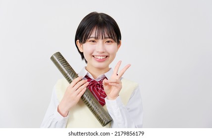 Asian high school student peace sign gesture with the diploma in a tube in white background