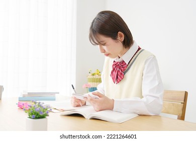 Asian high school student studying at home - Powered by Shutterstock