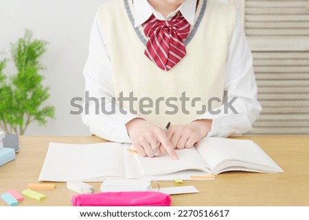 Asian high school student studying at home, no face