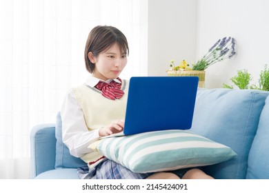 Asian High School Student Using The Laptop  At Home