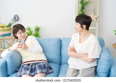 Asian High School Student Using The Smartphone Front Of Her Mother At Home