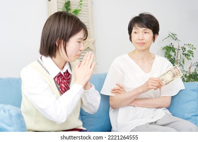 Asian High School Student Using The Smartphone Front Of There Mother At Home