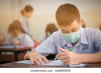 An Asian High School Students In A White School Uniform Wearing A Mask To Do Final Exams In The Midst Of Coronavirus Disease 2019 (COVID-19) Epidemic And PM 2.5.