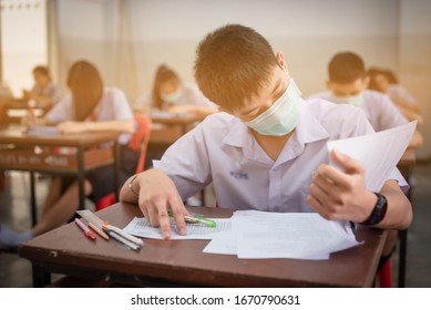 An Asian High School Students In A White School Uniform Wearing A Mask To Do Final Exams In The Midst Of Coronavirus Disease 2019 (COVID-19) Epidemic And PM 2.5.