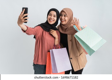 Asian Hijab Woman Friend Take Self Portrait Using Mobile Phone And Hold Shopping Bag