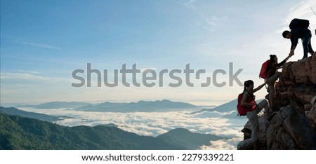 Asian hiking help each other on mountains view . teamwork concept