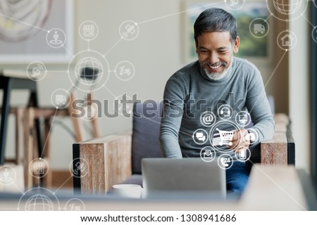Asian or Hispanic man using Laptop and credit card payment shopping online with icon customer network connection on screen and connecting with omni channel system. Older man satisfied with CRM system