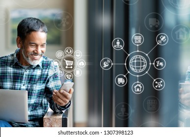 Asian or Hispanic man using smartphone mobile payment shopping online with icon customer network connection on screen and connecting with omni channel system. Older man is satisfied with CRM system