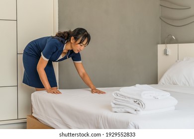 Asian Hotel Maid Arrange Fresh Towels Prepare For New Hotel Guest In Bedroom