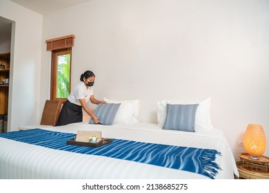 Asian Hotel Maid Setting Up Pillow On Bed Sheet In Hotel Room.