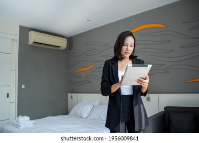 Asian Housekeeping Manager With Tablet Checking The Room Or Suite Of A Hotel.