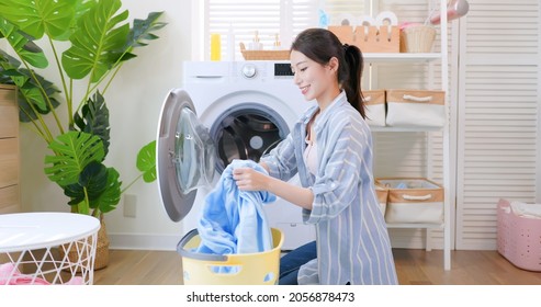 Asian Housewife Put Clothes Into Washing Machine Happily At Home