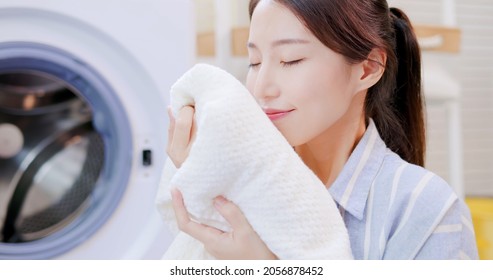 Asian housewife smell clean blanket happily at home - Shutterstock ID 2056878452