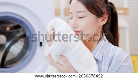 Asian housewife smell clean blanket happily at home