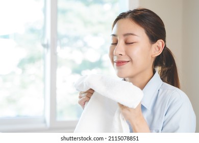 Asian Housewife Smelling Freshness Scent Of Clean Clothes