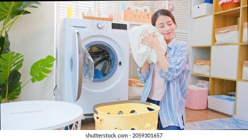 Asian Housewife Take Clothes From Washing Machine Happily And Smell Clean Blanket At Home