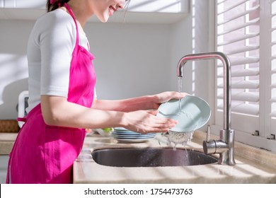 Asian housewife use natural cleaning detergent to wash dishes