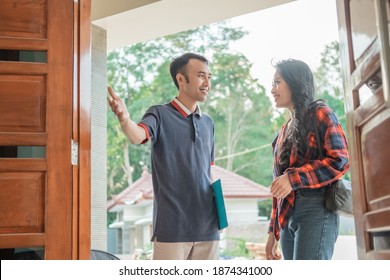 Asian Housing Developer With A Hand Gesture Invites Beautiful Woman To Enter The New House While Standing At The Door