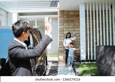 Asian Husband Waving Goodbye To His Wife And Child Before Going To Work