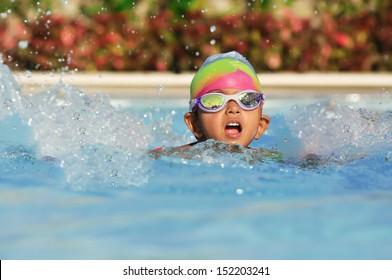 Asian Indian boy in the swimming pool with goggles in an Arab resort - Powered by Shutterstock