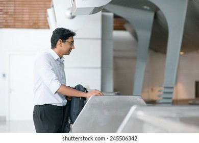 Asian Indian Businessman Standing By Airport Check In Counter