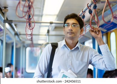 Asian Indian Businessman Taking Ride To Work, Standing Inside Train.