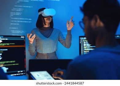 asian and Indian developer devops team testing  virtual reality coding and presentation  with ai prompt  at night in office