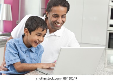 Asian Indian Father And Son, Man And Boy, Using Laptop Computer In The Kitchen At Home