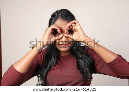 Asian Indian origin dark skin tone beautiful woman facial hand expression making faces hand signs funny looking through finger binocular