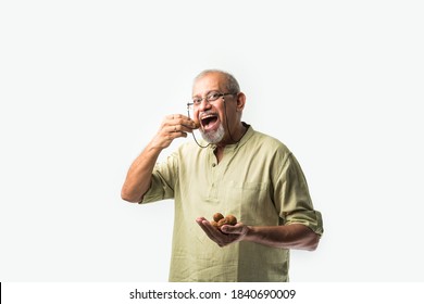 Asian Indian senior adult or old man showing dry fruits like Cashew, almond or walnut - healthy eating concept
