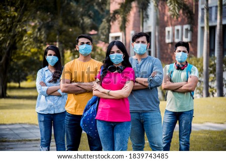 Asian Indian students wears face mask and follow social distancing norms in college or university campus after corona Pandemic unlock, focus on one student