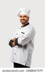 Asian Indian young male chef in uniform with folded hands, isolated white background