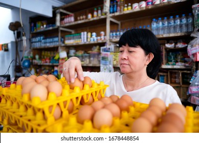 Asian Indonesian Women Arranging Eggs Inside Small Local Family-owned Business Store, Or Locally Called Warung. Location Is In Tasikmalaya, Indonesia. Selective Focus.