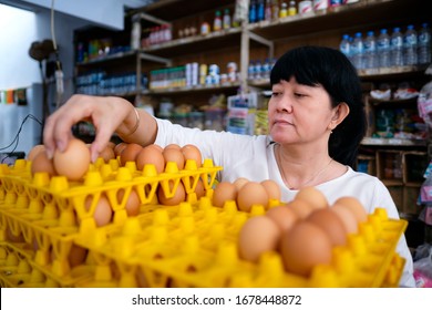 Asian Indonesian Women Arranging Eggs Inside Small Local Family-owned Business Store, Or Locally Called Warung. Location Is In Tasikmalaya, Indonesia. Selective Focus.