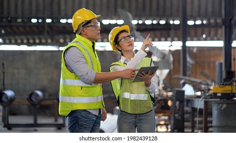 asian industrial Engineer manager man wearing eyeglass and helmet   discussion with mechanic worker woman while using digital tablet checking industry manufacturing large factory . inspection  - Powered by Shutterstock