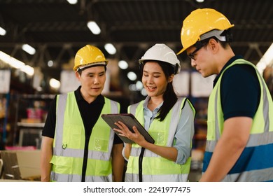 Asian Industrial Engineers talk with warehouse industrial workers using laptops to explain the procedure. They Work at the Heavy Industry Manufacturing Facility and industrial environments. - Powered by Shutterstock