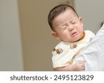 Asian infant crying baby. child tired and hungry 
in mother arms. Children cry. Asia baby screaming. emotion child concepts 