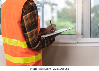 Asian inspector checking structure of new property and taking note in the clipboard for review and fix the house before sell to client - Shutterstock ID 2281205051