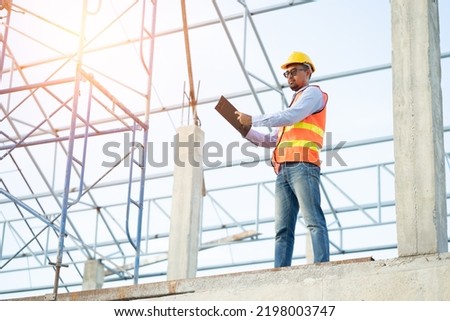 Asian inspector checking structure of new property and taking no