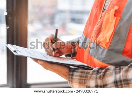 Asian inspector checking structure of new property and taking note in the clipboard for review and fix the house before sell to client