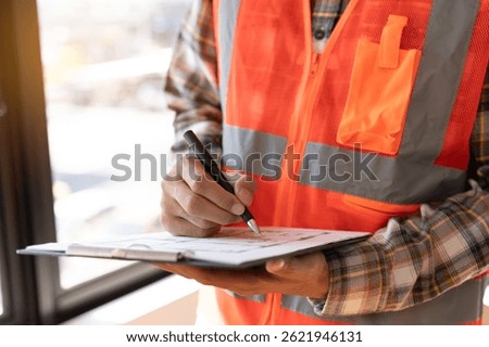 Asian inspector checking structure of new property and taking note in the clipboard for review and fix the house before sell to client