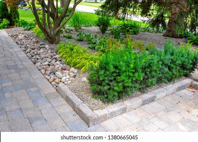 Asian Inspired Landscaping Features Various Textures And Types Of Plants And Natural Stone, And Tumbled Paver Edging To Help Retain The Grade.