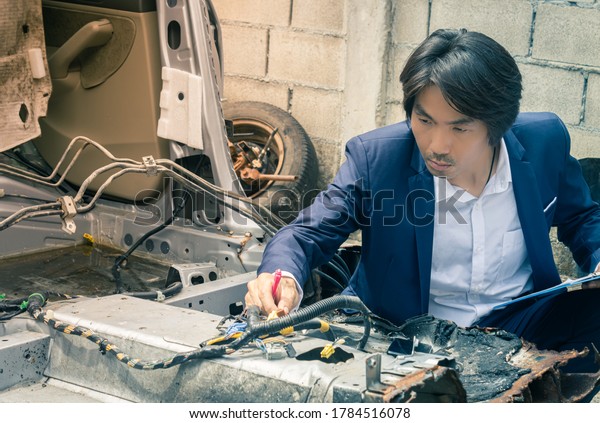 Asian Insurance Agent or Insurance Agency in Suit\
Inspecting Car Crash from Accident for Insurance Claim at Outdoor\
Place in Vintage Tone