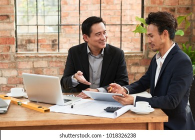 Asian Investors Discussing Construction Project At Business Meeting