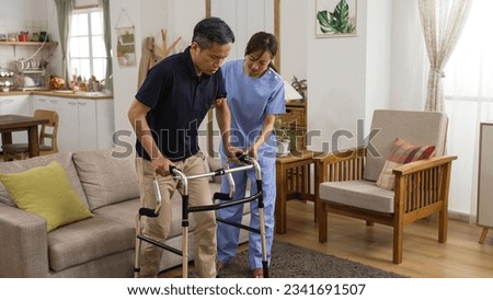 asian Japanese senior stroke patient undergoing rehab exercise with a walker at home. the woman nursing aide assists him during home visit