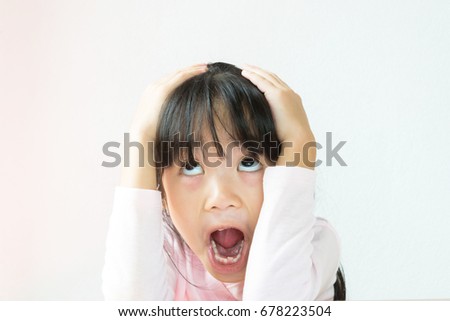 Asian kid afraid of falling something.she use her hands on her head.